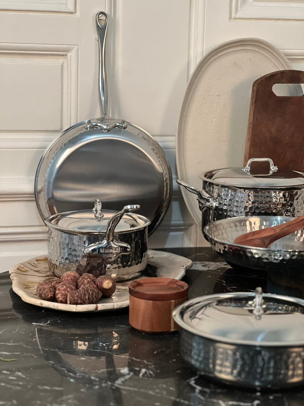 Mauviel M'Elite hammered stainless steel cookware on a kitchen counter